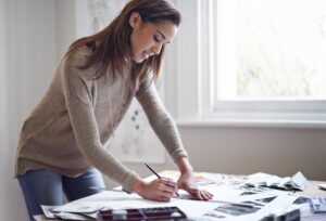 Expressing herself creatively. A young woman working on her portfolio at home. Expressive Arts Education: A Pathway to Healing and Self-Discovery 